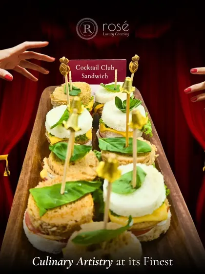 A tray of our signature Cocktail Club Sandwiches, elegantly presented and ready to be served. This image showcases our culinary artistry in creating classic appetizers with a refined touch.
