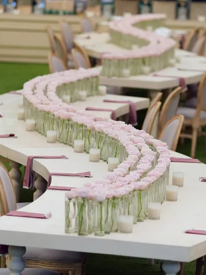 We designed this unique serpentine table for the family dining area. The centerpiece was a simple but elegant line of single pink roses in glass vases, running the entire length of the table.