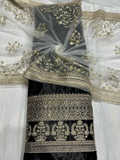 A classic black velvet fabric, intricately embroidered with gold thread and sequins. Paired with the floral embroidered net, it creates a timeless and elegant ensemble.