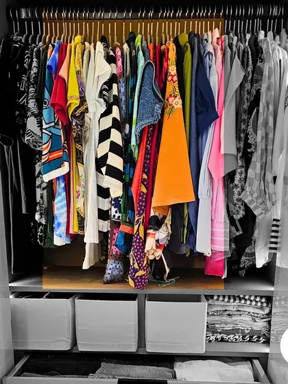 We bring color and order back into your life, starting with your wardrobe. This closet shows a beautiful array of clothes, perfectly hung and easy to see, turning a daily chore into a joyful experience.