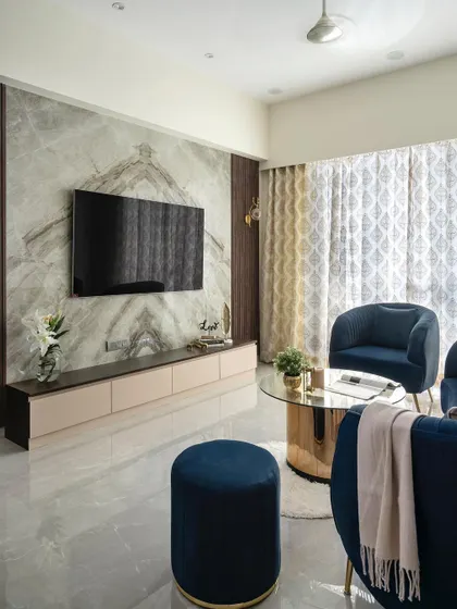 The actual TV wall, demonstrating the successful execution of the book-matched marble cladding, which creates a stunning, symmetrical focal point in the living room.