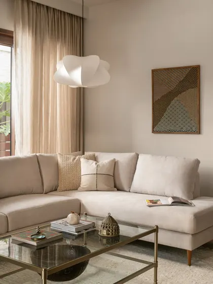 Earth tones carry through the home, connecting the living spaces across both levels. This formal living area uses soft beiges and natural textures to feel warm and inviting while retaining a light, airy presence.