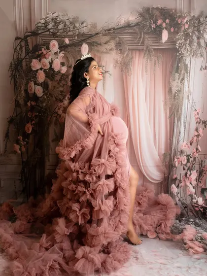 A powerful and majestic pose in a dramatic pink ruffled gown. The addition of a crown completes this queenly portrait.