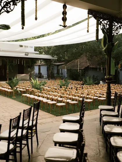 Guest seating arranged on the lawn, with chairs decorated with simple jasmine strings.