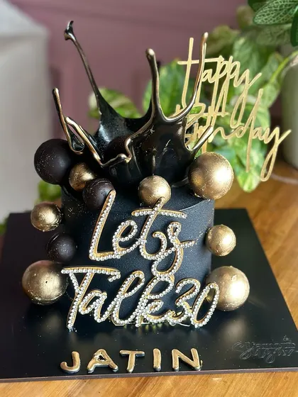 Celebrating 30 in style with this stunning black and gold birthday cake. The design features a dramatic black splash effect, gold spheres, and a sparkling "Let's Talk 30" topper.