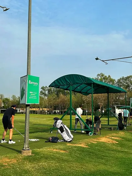 The range isn't just a place, it's a ritual. A golfer prepares for his shot on a sunny day.