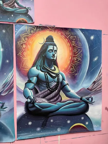 A close-up of one of the finished Shiva paintings, showing the detailed mandala and the galaxy background.