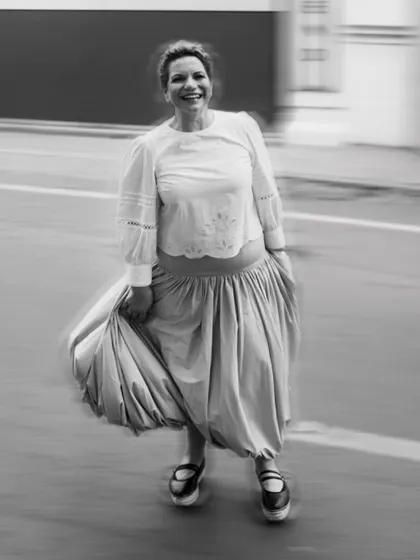 A candid black and white shot with motion blur, capturing her happy energy as she explores the city streets.