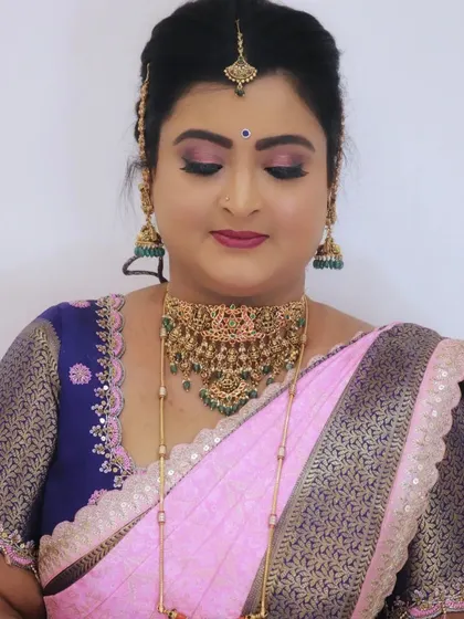A close up of the eye makeup, featuring a soft pink shimmer that beautifully complements the client's pink and blue silk saree.