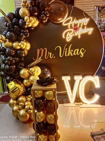A close-up of a personalized black and gold birthday setup, showing the custom name and light-up initials.