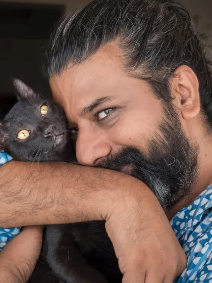 A beautiful moment between a cat dad and one of his three rescued cats. The comfort and love are palpable in this at-home portrait.