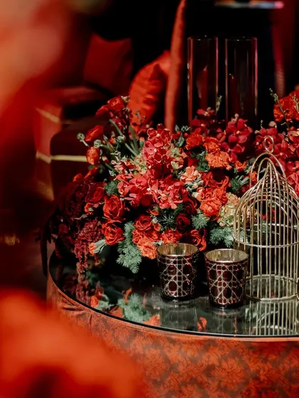 We designed intimate seating nooks with plush velvet sofas and ottomans. Each area was decorated with red floral arrangements and candles, providing comfortable and beautiful spaces for conversation.
