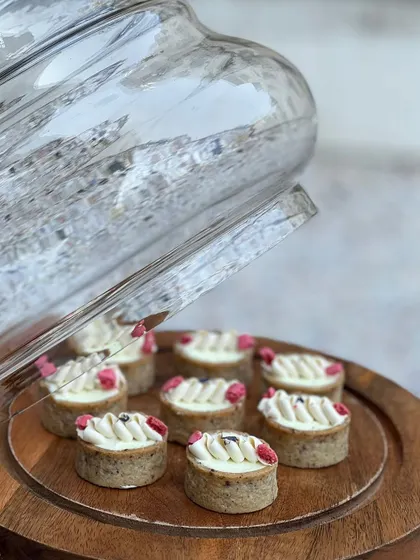 Delicate lemon tarts with a piped cream topping and a hint of berry. The tartness of the lemon is perfectly balanced by the sweet, buttery crust.