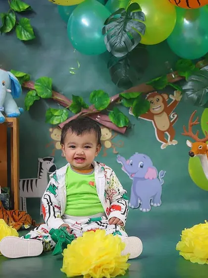 A happy smile from our jungle explorer, surrounded by his favorite animal friends and a vibrant green backdrop.