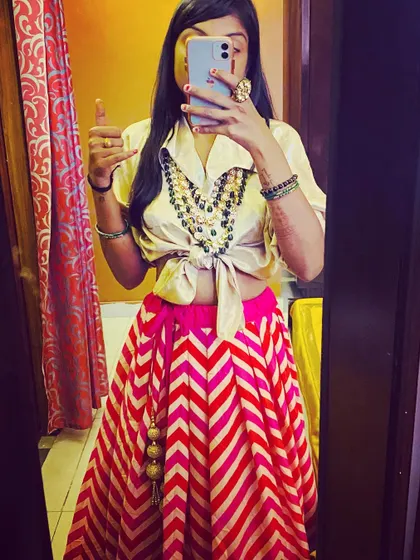 Here’s a fun fusion look. I’ve paired a traditional chevron-print lehenga skirt with a modern satin shirt tied at the waist and layered with chunky necklaces for a unique indo-western vibe.