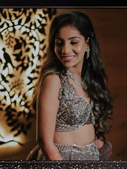 The bride posing against a beautifully lit backdrop. Her grey lehenga and diamond jewellery create a sophisticated and modern sangeet look.