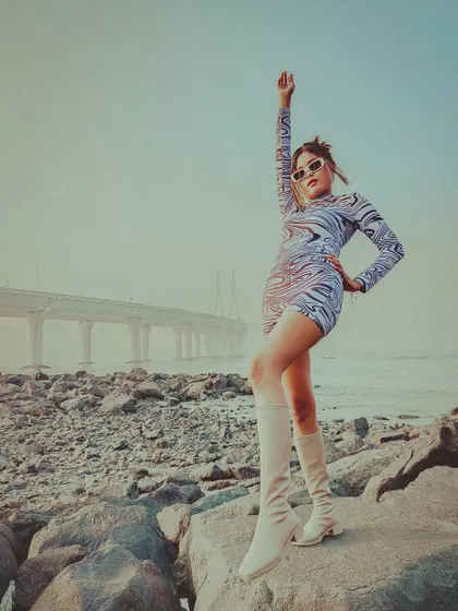 A wide shot showing the model against the vast backdrop of the sea and the Bandra-Worli Sea Link, creating a sense of freedom and style.