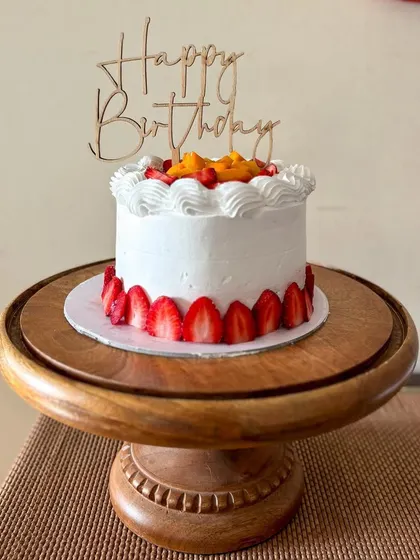 Celebrating summer with this fresh fruit cake. It's a light vanilla cake filled with layers of fresh cream and fruit, topped with mangoes and strawberries and decorated with sliced strawberries around the base.