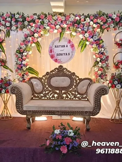 An elegant engagement stage featuring a delicate floral arch in pastel pinks and whites. We included a personalized sign with the couple's names, hanging floral hoops, and coordinated flower stands to complete this romantic look.