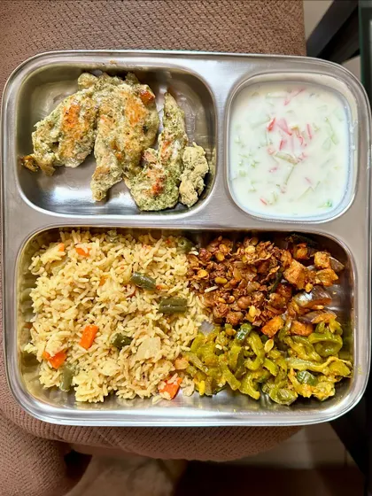 A high-protein meal with vegetable rice, malai chicken, sautéed vegetables, and a refreshing raita.