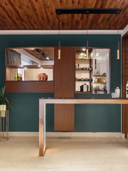 A suave bar takes up one corner of the living room. The bespoke bar counter features a black granite top and a tiled base, while the display behind hosts a collection of shot glasses from the clients' travels.