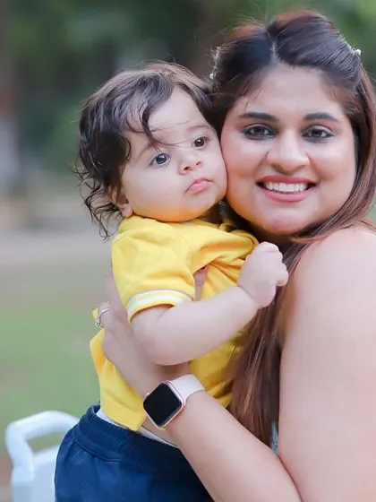 A sweet hug between a mother and her son, with pastel balloons in the background from his pre-birthday shoot.