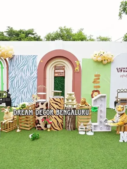 A grand safari theme for twins, Arhaan and Nirvana. The wide setup includes multiple backdrops, animal cutouts, and two sets of name signs.