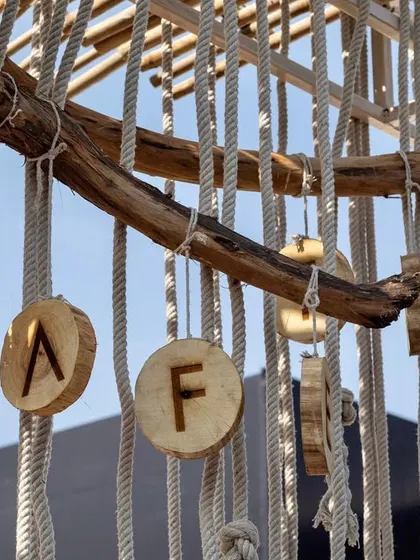 A close-up of the custom Cafe Tesu signage we created. The letters were burned onto individual wooden discs and hung from a natural tree branch, reinforcing the cafe's rustic, artisanal theme.