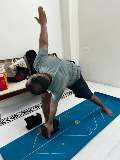 Using a block for support in Triangle Pose. This modification allows my client with Gout to get the full benefits of the stretch without straining his body.