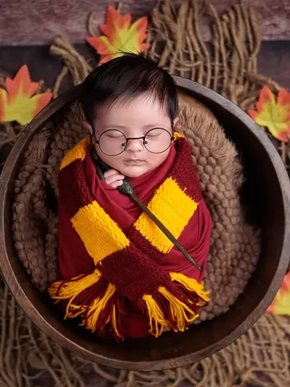 Wingardium Leviosa! Our little wizard is ready for Hogwarts, complete with a Gryffindor scarf, round glasses, a magic wand, and his own Hedwig. A magical theme for any Harry Potter fan.