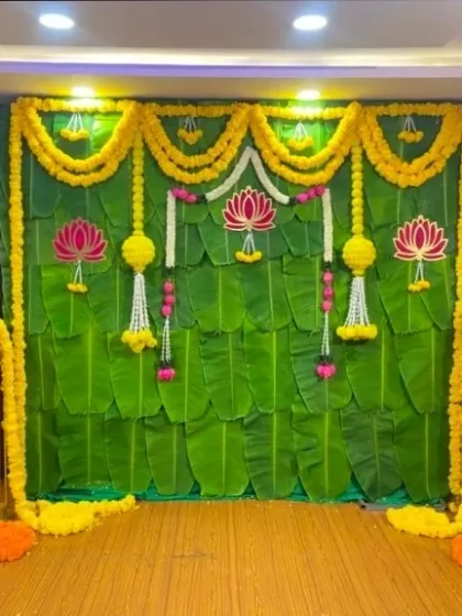 We specialize in traditional decor, creating authentic backdrops like this one made from fresh banana leaves and marigold garlands. This is perfect for religious ceremonies, housewarmings, or traditional photo booths.