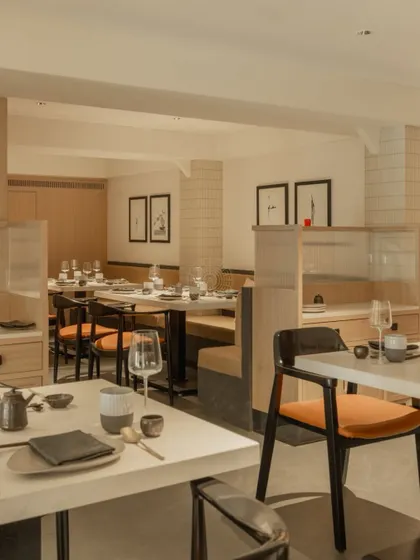 The dining space is arranged to feel both open and intimate, with low partitions creating distinct zones without closing off the room.