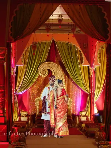 The grandeur of the wedding stage is captured in this wide-angle shot. It highlights the scale of the decor and the regal presence of the couple.