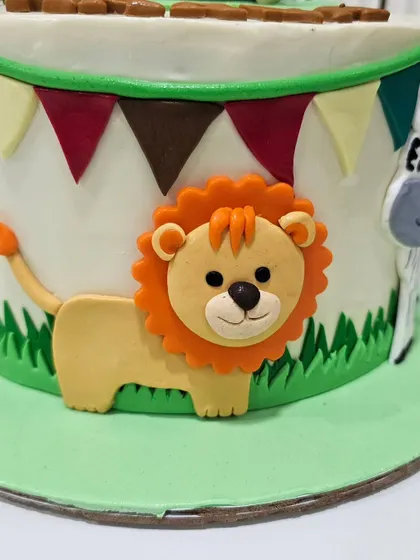 A close-up of a fondant lion on a safari-themed cake. My classes cover 2D relief techniques for decorating the sides of cakes with cute animal characters.