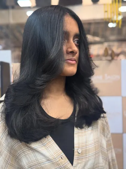 This angle shows the beautiful side-swept layers and the healthy, natural shine of the hair after a fresh cut.