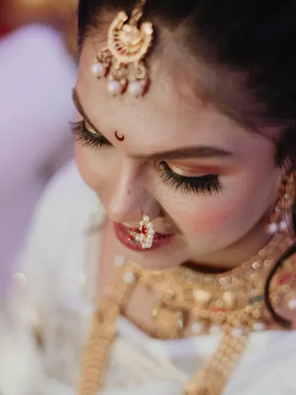 An artistic, high-angle shot focusing on the bride's beautiful eye makeup, bindi, and nath. These detailed portraits are perfect for capturing the artistry of the bridal look.