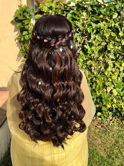 The sunlight catches the diamond-like accessories, creating a beautiful, shimmering effect on the dark hair.