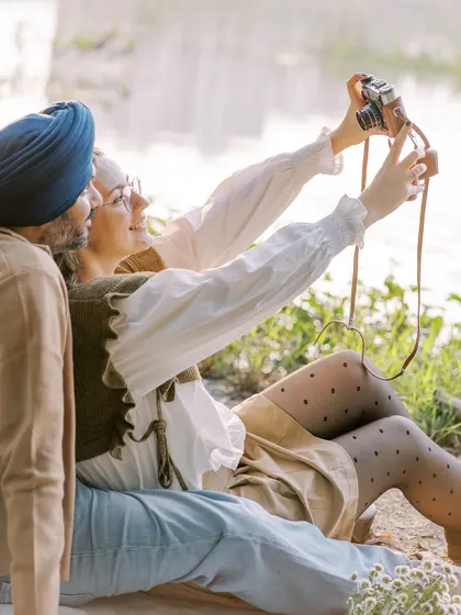 A fun, candid moment where the couple takes a selfie with a vintage film camera. It shows their playful side and their shared love for creating memories together.