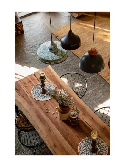 An overhead view of the dining table, showing the mix of different pendant lights that add an eclectic, collected-over-time feel.