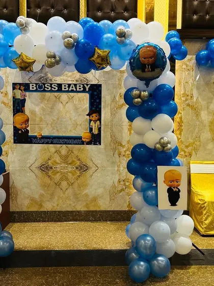 A "Boss Baby" themed photo booth setup. It includes a balloon arch and a custom frame for guests to take pictures.