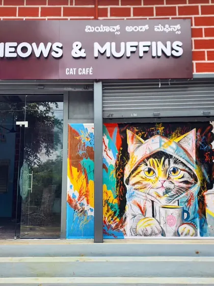 The exterior of Meows & Muffins cat cafe, where our colorful mural of a cat in a hoodie makes the entrance impossible to miss.