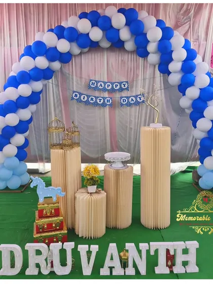 A simple blue and white balloon arch with plinths, perfect for a naming day or first birthday.
