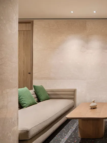 This nook within the Elevate Clubhouse demonstrates our use of texture and subtle color. The neutral tones of the wall and sofa are accented with green cushions, creating a calm and inviting space for quiet conversation or relaxation.