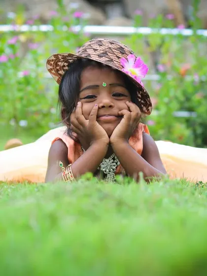 The best moments are the natural ones. For this outdoor child portrait, we went to a park, and I captured this sweet, candid expression as she relaxed in the grass, showing her genuine personality.