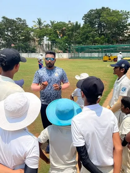 A coach engages with a group of young players in a circle. These sessions are for discussing tactics, reflecting on performance, and building a strong mindset.