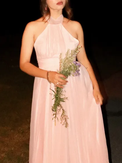 A close-up on the details of the pink Jardinvue dress and the wildflower accessory.
