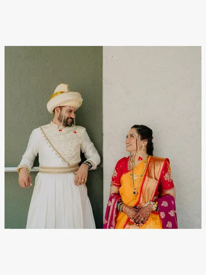 A simple, minimalist portrait of the couple looking at each other. The clean background puts all the focus on their connection and their colorful wedding attire.