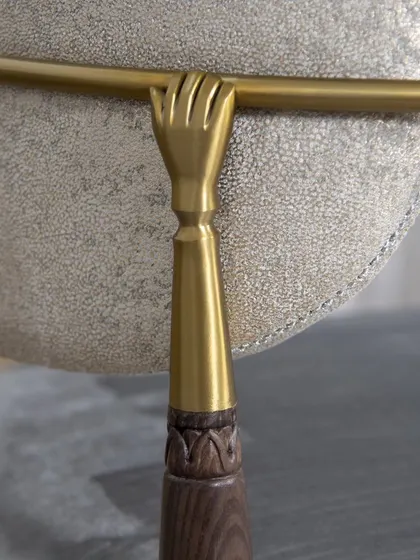 The details make the design. This close-up of our Main D’Or Chair showcases the fine craftsmanship that defines our work. The golden hand delicately grasping the backrest is a nod to an era of opulence, while the lush velvet and subtle wood carving create a rich tactile experience. It's a piece of art.