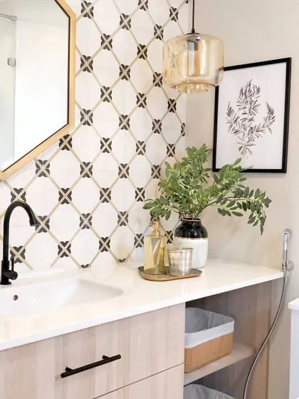 In the master bathroom of the JWD Marq Home, I used a beautiful patterned tile as a backsplash to create a focal point. Paired with a light wood vanity, a hexagonal mirror, and a glass pendant light, the result is a space that feels both fun and sophisticated.