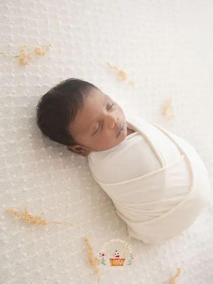 A full-body shot of a baby in a classic swaddle. This pose is all about simplicity and showing how tiny and curled up your newborn is in their first few weeks.